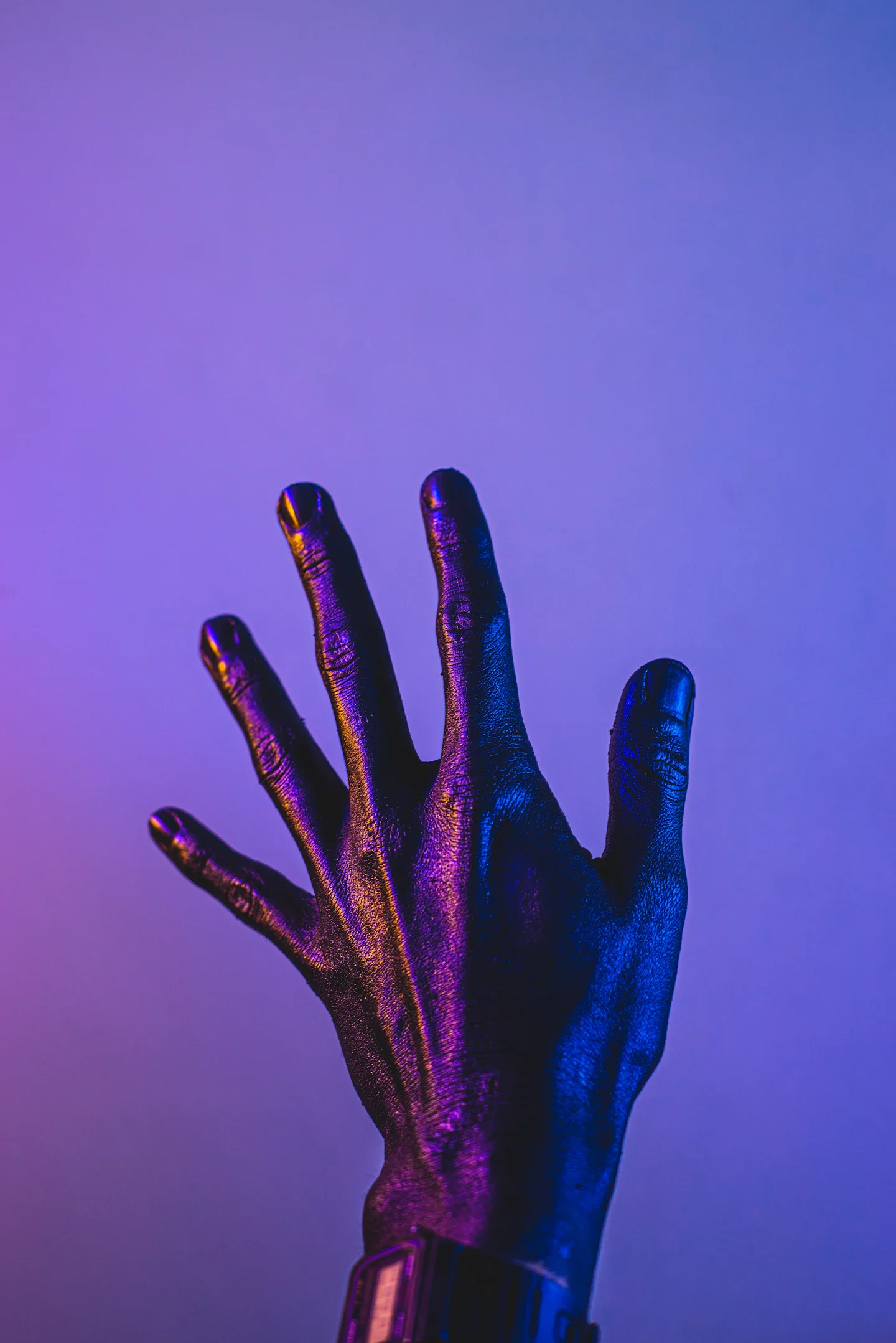 A person's hand covered in blue paint — the organic body marked, transformed, and overwritten by its own creation.